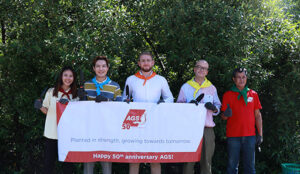 The AGS Thailand team holding a large "Happy 50th Birthday AGS!" banner to celebrate five decades of global excellence.